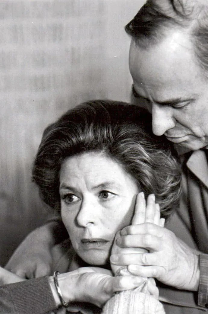 A black and white photo of a man and woman holding hands, featuring Ingrid Bergman.