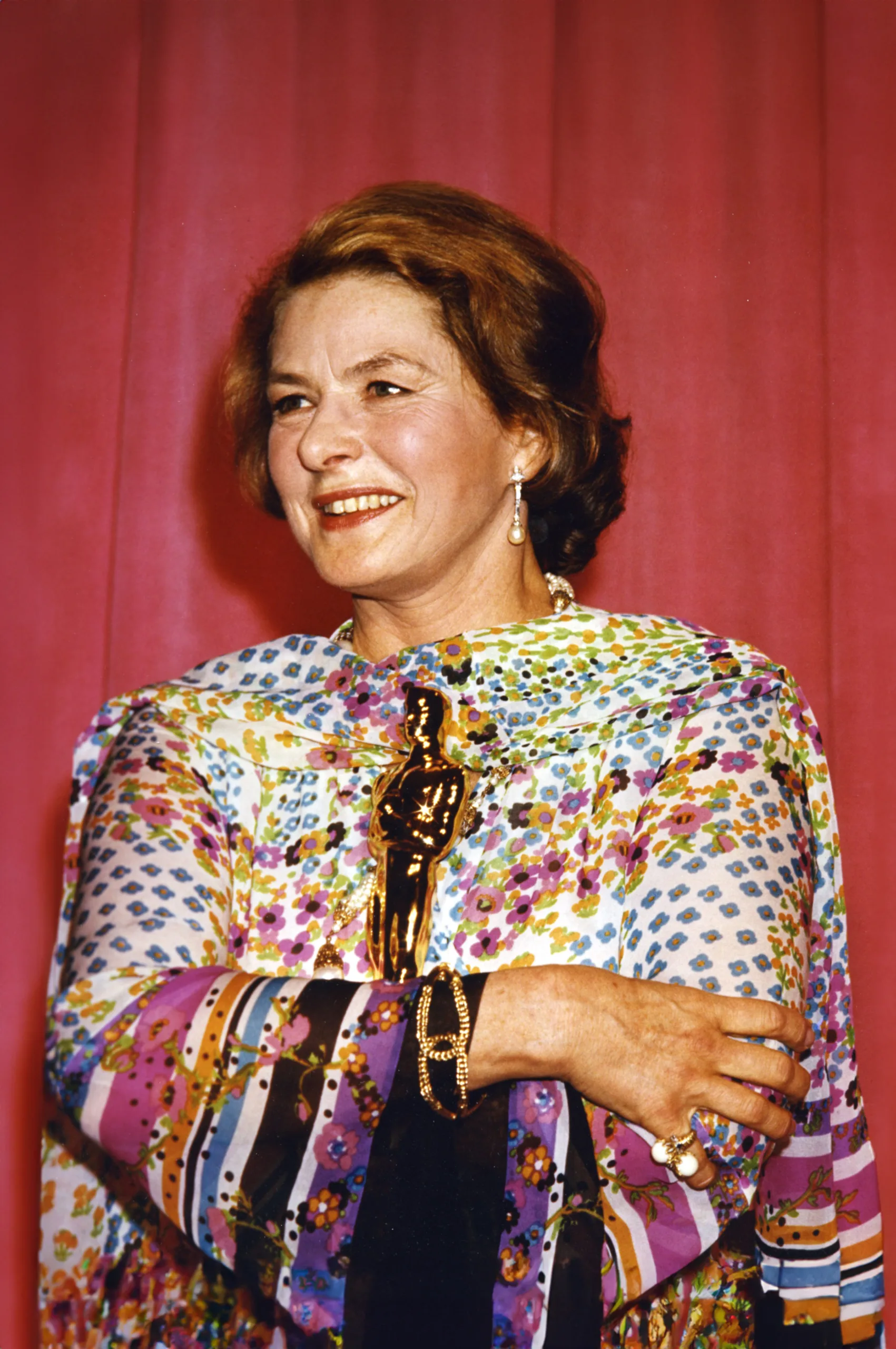 A woman, Ingrid Bergman, holding an oscar award.