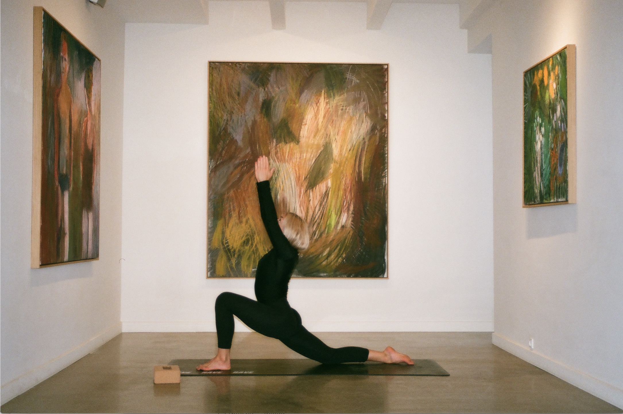 A woman practicing yoga in an art gallery.