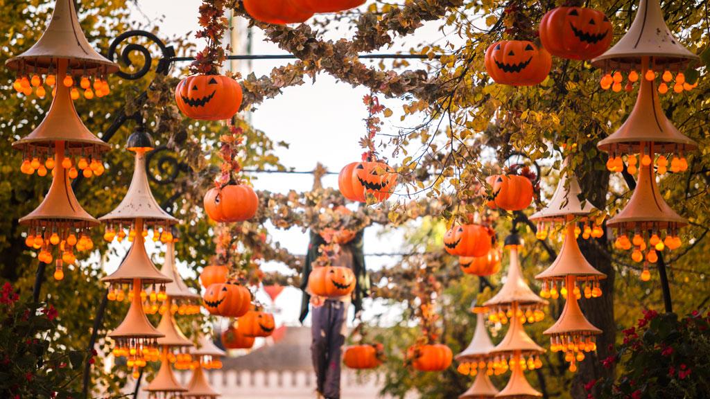 A walkway decorated with pumpkins and lanterns.