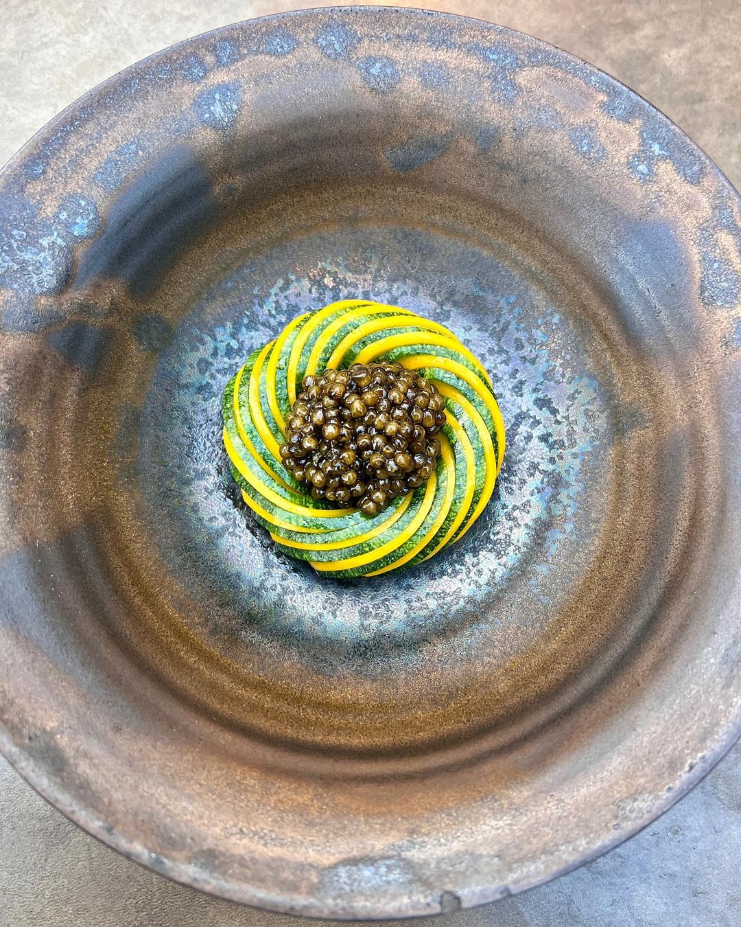 A plate with a yellow and green dish on it at Copenhagen restaurants.