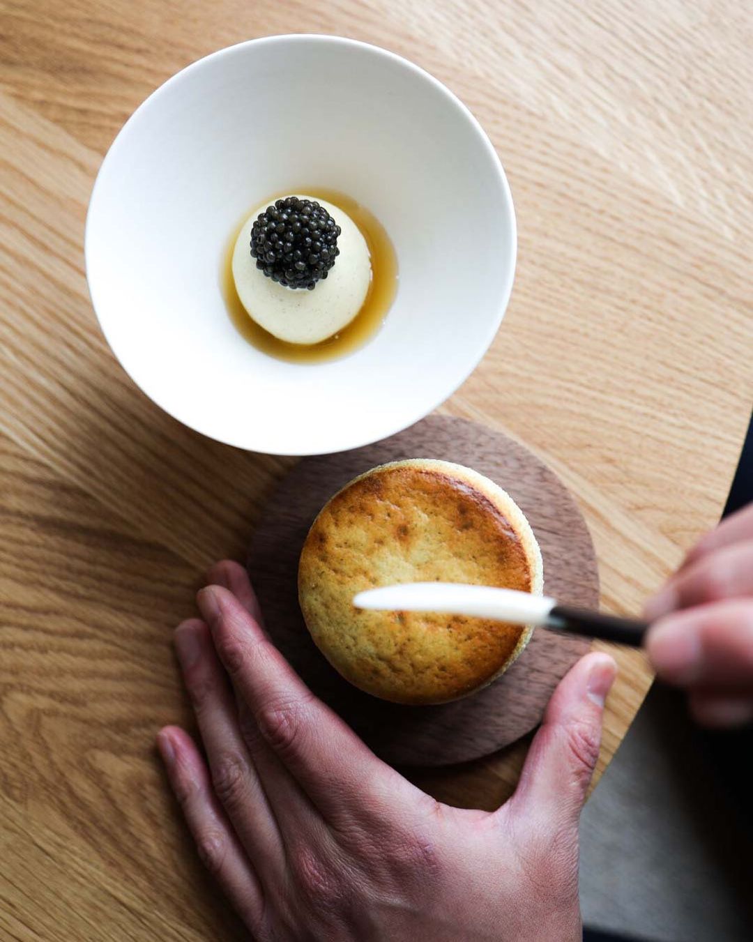 A person is holding a bowl of caviar at a Copenhagen restaurant.