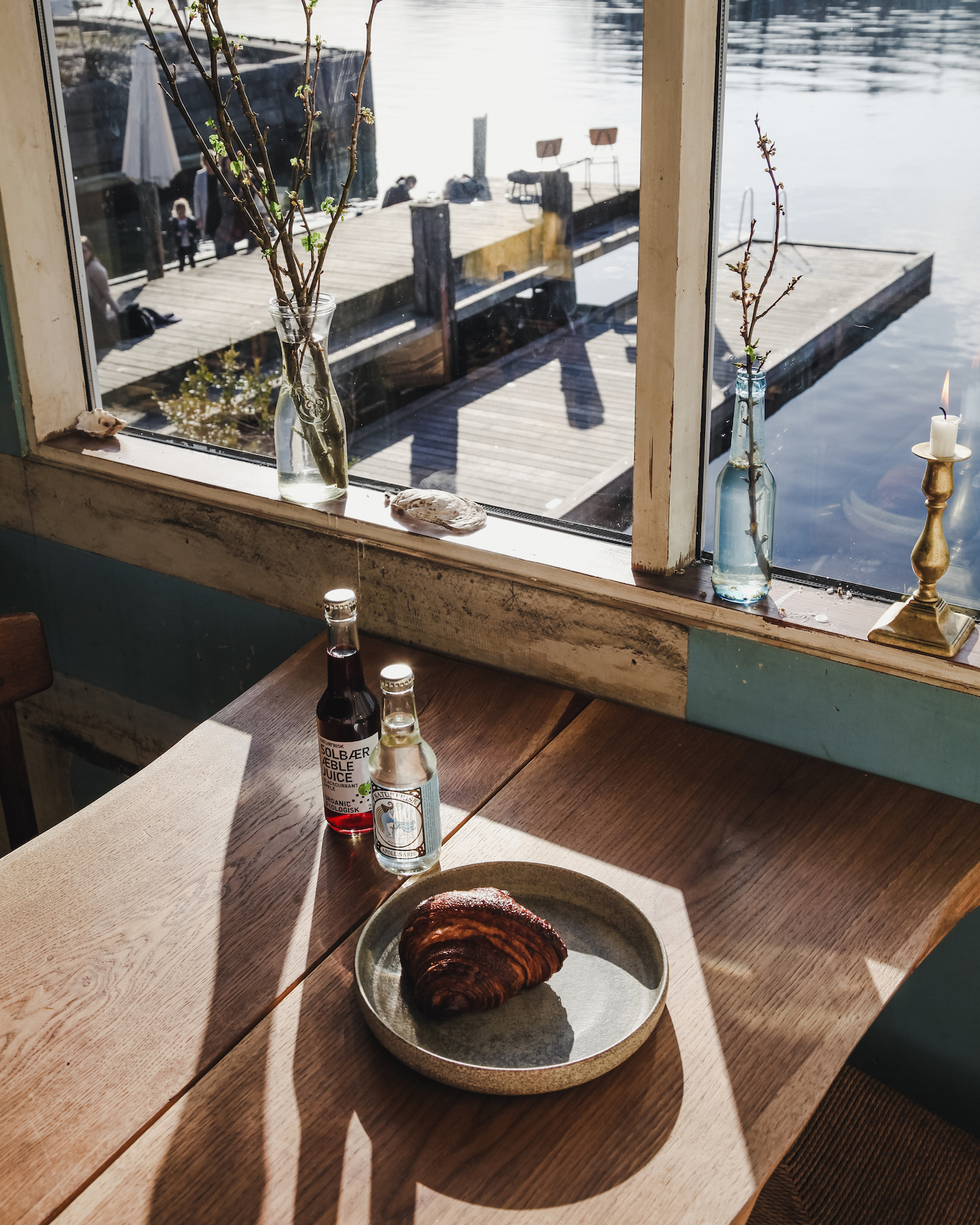 A wooden table next to a window with a view of the water in Copenhagen.