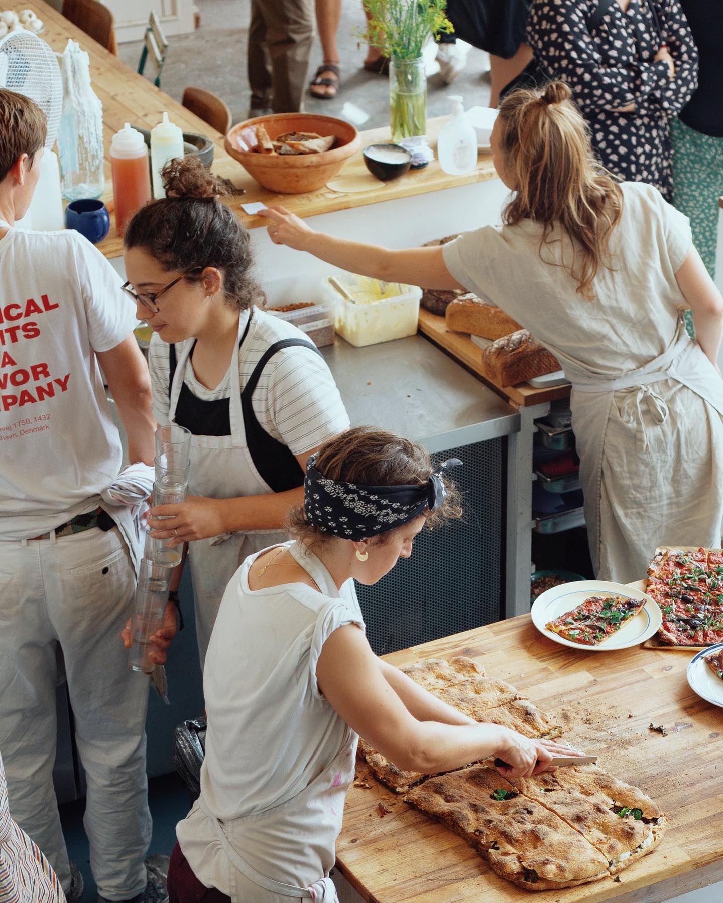 A group of people preparing food in a Copenhagen restaurant kitchen.