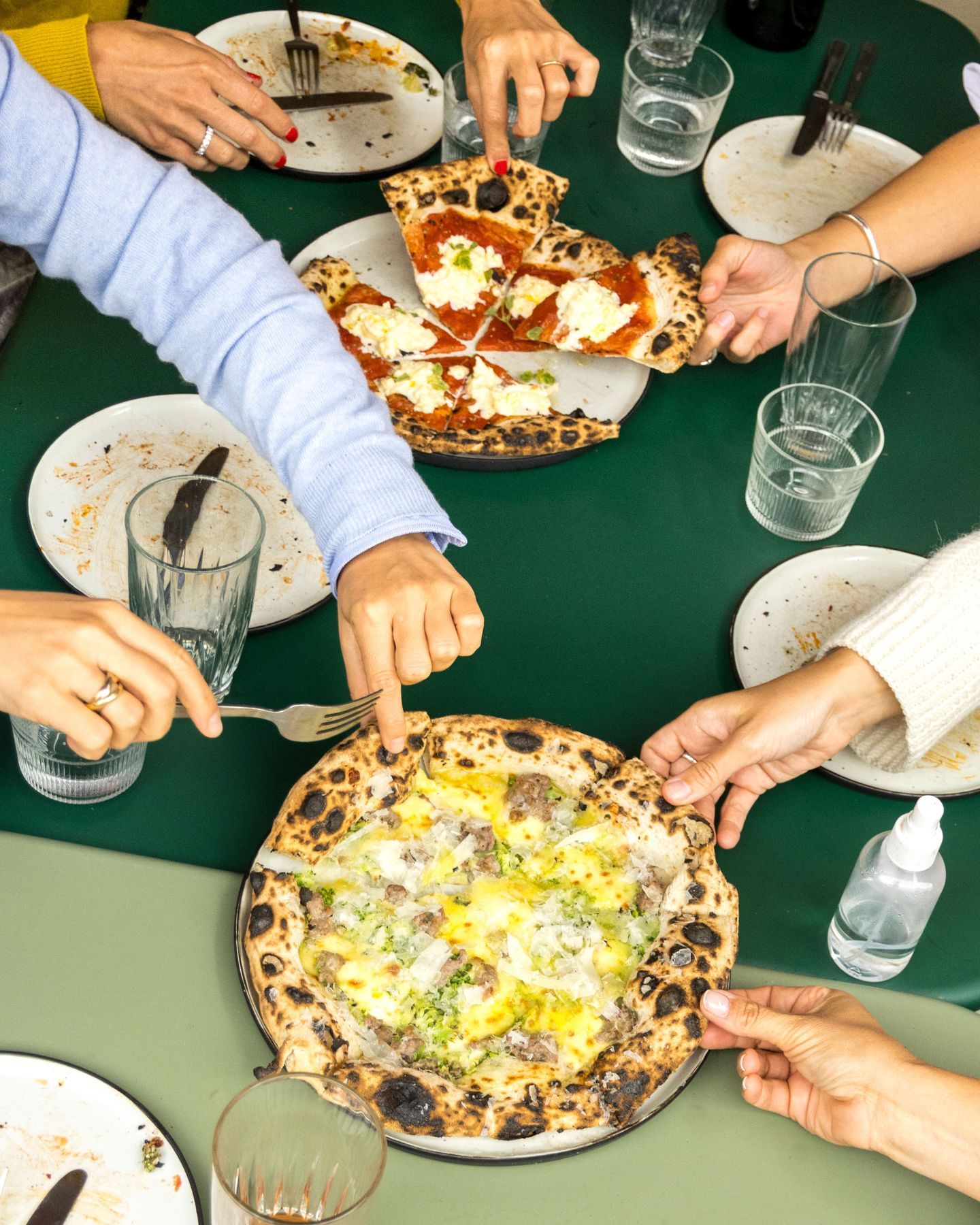 A group of people eating pizza at a Copenhagen restaurant.