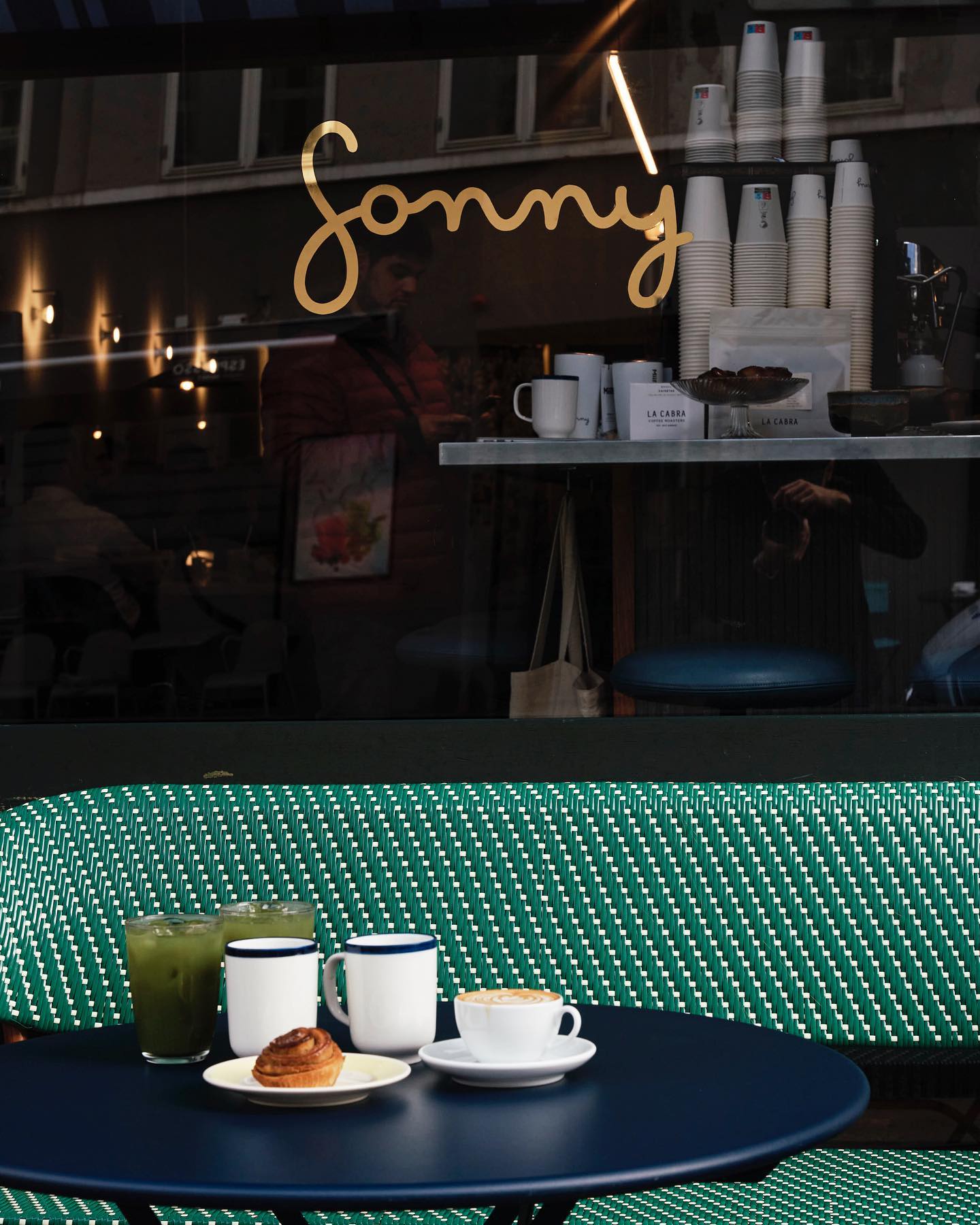 A table with a cup of coffee and a plate of pastries in Copenhagen restaurants.