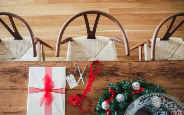 A wooden table with a christmas present on it.