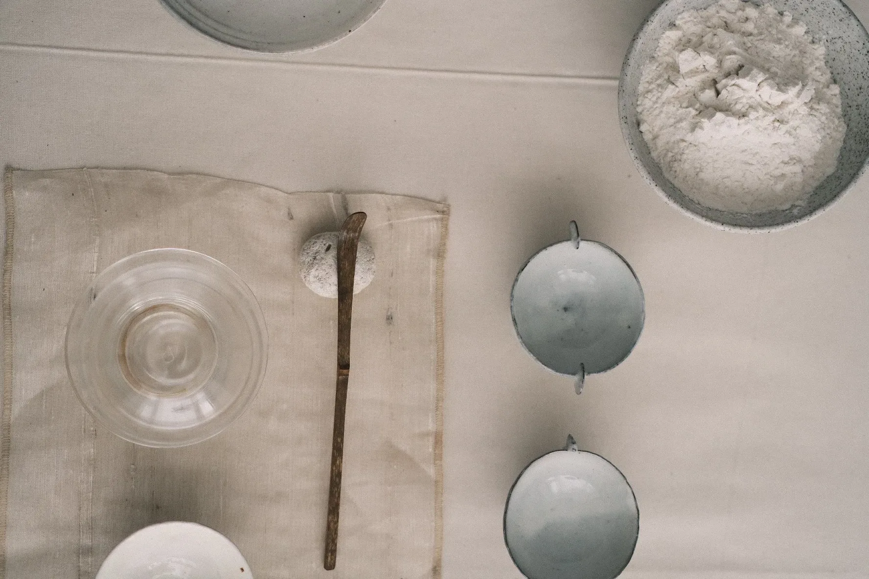 A table with bowls and spoons on it, illuminated by the warm sun.